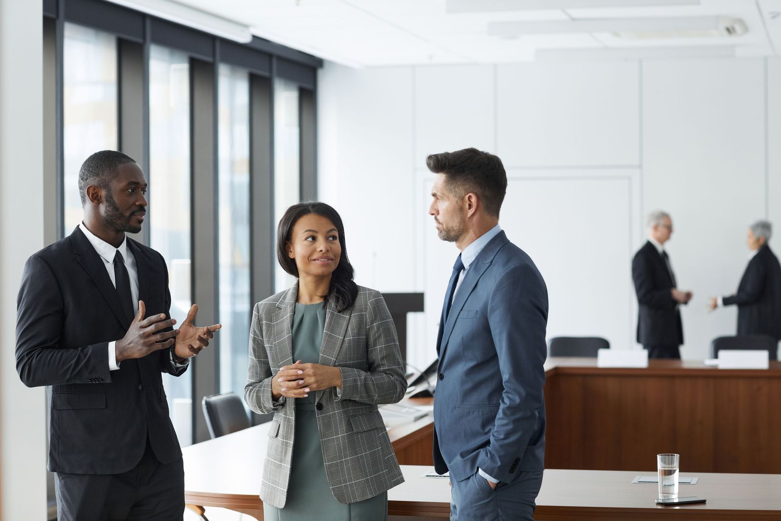 Three people talking in a bright office